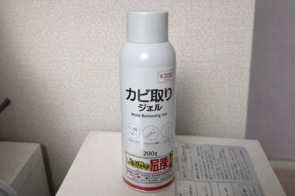 棚の上に置かれた白いカビ取りジェルのボトル。ラベルには「カビ取りジェル」と表示され、内容量200gと価格300円の記載がある。