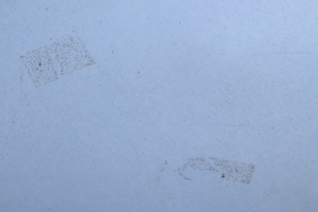 白い収納ボックスに貼っていたマスキングテープを半年以上放置して剥がしたあと。粘着跡と汚れが残っている状態