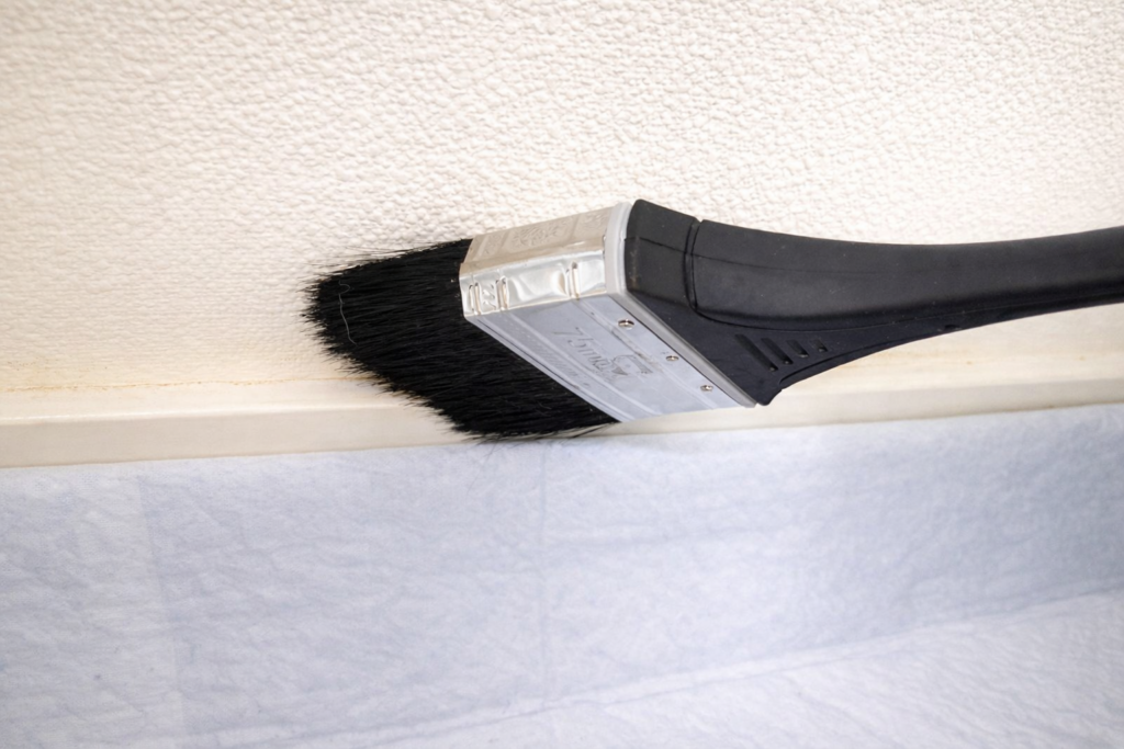 黒いハケで巾木の汚れを掃く様子
巾木と床の境目の汚れが確認できる